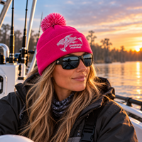 Woman wearing pink ShredFin Cold Front fishing beanie on a boat